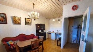Ein gemütliches Wohnzimmer mit einem Holzesstisch, einem roten Sofa und einer Chandelier.