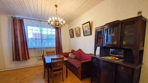 Ein gemütliches Zimmer mit einem Holzesstisch, einer Couch und einem Schrank.