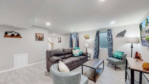 Un salon moderne avec un canapé en cuir, une table basse et un coin repas comprenant une table et des chaises.