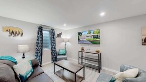 Un salon moderne avec un canapé, une table basse et une petite table d’appoint.