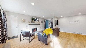 A modern living room with a fireplace, leather sofa, and a dining area. - Spacious Family Retreat in Denver (Denver)