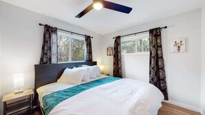 A bedroom with a bed, curtains, a ceiling fan, and a window. - Spacious Family Retreat in Denver (Denver)