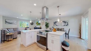 Una cocina moderna con armarios blancos, una isla central y un horno empotrado.