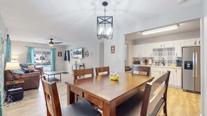 Un appartement moderne comprenant un coin repas, une cuisine et un salon.