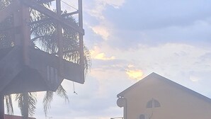 Eine Rasenfläche mit Pool, einem Basketballkorb und einem Gebäude mit geneigtem Dach im Hintergrund.