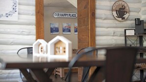 A cozy interior with a wooden wall, a sign reading "OUR HAPPY PLACE," and a coffee machine.
