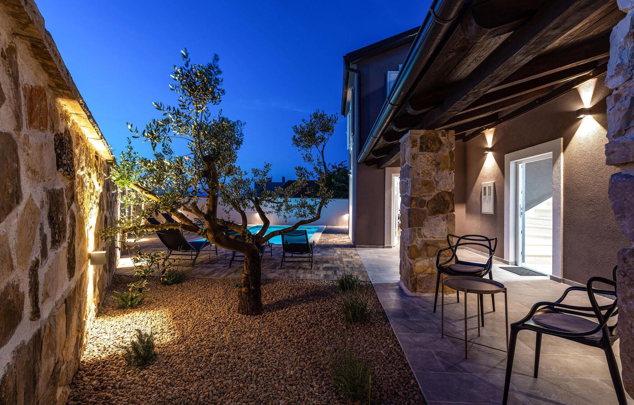 A stone building with a pool and outdoor seating.