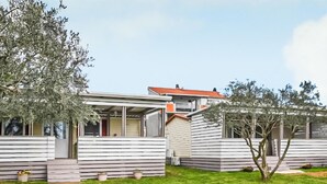 Una casa moderna de dos pisos con techo plano y ventanas grandes.