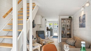 Un intérieur moderne comprenant un escalier, un coin repas, un salon et une cuisine.