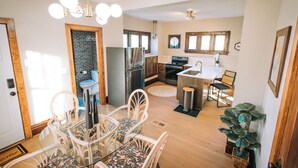 A modern kitchen with a dining area, stainless steel appliances, and a potted plant. - 3 Min to downtown & Falls Park, 10 min to Airport - Clean King Bed Home (Sioux Falls)