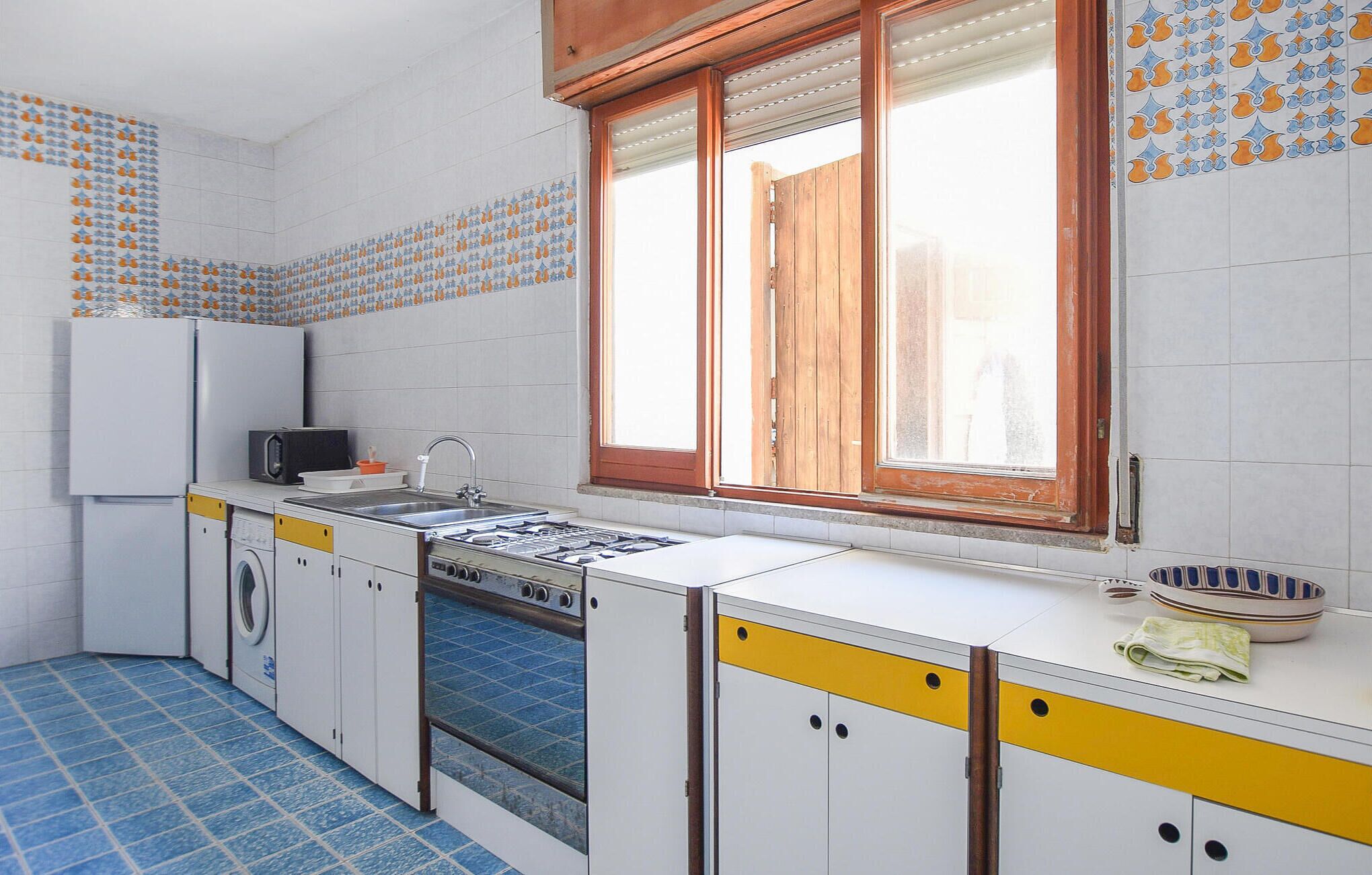Una cocina compacta con lavadora, microondas y estufa.