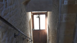 Una escalera de piedra que conduce a una puerta de madera con un ventanal encima.