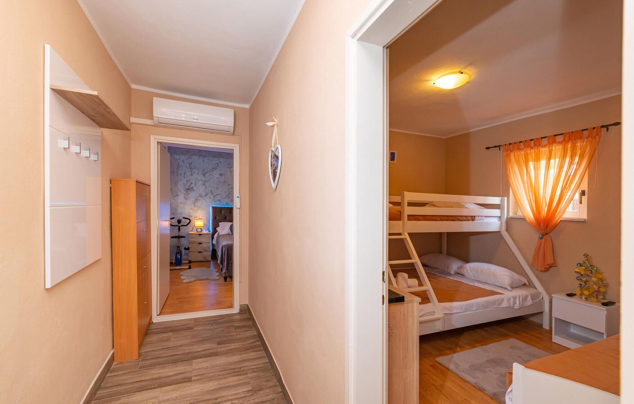 Una stanza funzionale con un letto a castello, una scrivania e un angolo cottura.