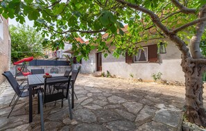 Enjoy a peaceful retreat in a serene outdoor setting with a patio, dining area, and lush garden.