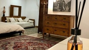 A bedroom with a bed, a dresser, a rug, and a bottle of essential oil. - Entire apartment in the heart of Tuscany, between Val di Chiana and Val d'Orcia. (Sinalunga)