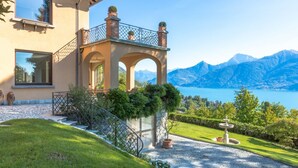 A house with a balcony, a fountain, and a view of mountains and a lake. - Villa Gaia Luxury Retreat with Private Pool in Menaggio (Menaggio)