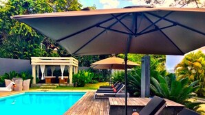 A poolside area with lounge chairs and umbrellas, a wooden deck, and a small gazebo. - Guest Friendly- 20% off for Bookings in 2024 (Sosua)