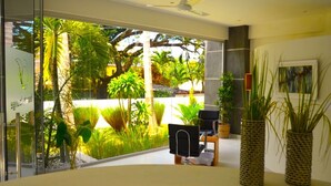 A modern room with a large window, a ceiling fan, and a view of tropical greenery outside. - Guest Friendly- 20% off for Bookings in 2024 (Sosua)