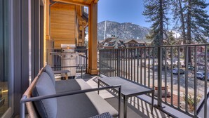 A balcony with a sofa, a grill, and a view of a mountain and buildings. - Resort! Walk to Skiing/ Casinos/ Beach, Pool & Spa, Gym, Grill: Zalanta Oasis (South Lake Tahoe)