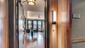 A hallway with wooden flooring leading to a dining area with a table and chairs. - Resort! Walk to Skiing/ Casinos/ Beach, Pool & Spa, Gym, Grill: Zalanta Oasis (South Lake Tahoe)