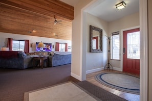 Relax in a spacious living area with a high ceiling, comfortable seating, and a large mirror.
