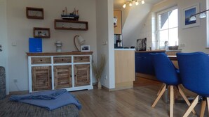 Eine moderne Küche mit Essbereich, Holzschränken und einem blauen Stuhl.