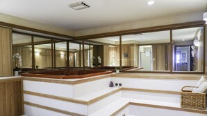 Un espace bien-être comprenant une grande baignoire, des marches en bois et un panier en osier.