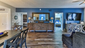 A living room with a wooden dining table, chairs, a sofa, and a TV. - Waterfront Sleeps 6 w/private boat dock and heated pool. (Crystal River)