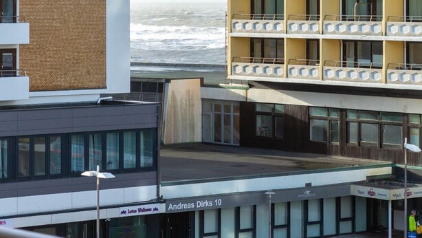 Hotel de vários andares com varandas, vista para o mar e placa indicando Andreas Dirks 10.