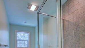 A bathroom with a glass-enclosed shower, a bathtub, and a toilet. - Ingen Trafikk secluded forest oasis (Bald Head Island)