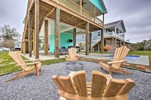 A wooden deck with Adirondack chairs and a fire pit, overlooking a residential area.