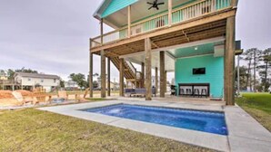 A two-story building with a pool, wooden deck, and a covered patio area. - Bay St Louis Water Front Home w/ Private Pool + Boat Dock (Bay St Louis)