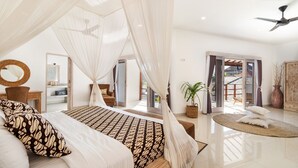 A spacious bedroom with a large bed, a ceiling fan, and a view of the outside balcony. - Luxurious 4BR Villa with Pool, Bali Villa 2206 (Bali)