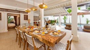 A spacious dining area with a long wooden table set for breakfast, surrounded by wicker chairs. - Wonderful 4BR Villa with Pool, Bali Villa 2212 (Bali)