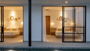 Ett hotellrum med två sängar, ett stort fönster och utsikt över en pool.