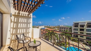 Ein Balkon mit Pool, Stühlen und einem Tisch.