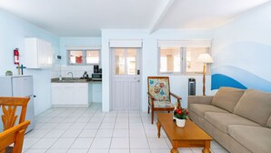 A compact living space with a kitchenette, a dining area with a table and chairs, and a sofa. - 2BR 1BA Ground Level in the Heart of Aruba ~ Pool (Noord)