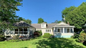 A two-story house with a front porch, a covered porch, and a well-maintained lawn. - Beautiful 3 Bedroom Lakefront Home (Sweet Valley)