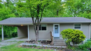 A single-story house with a covered porch, a front door, and a small front yard with a tree and shrubbery. - Stock Cottage Cozy 2 BR, 2 Bath House next to Biology Trails and SAU (Ooltewah)