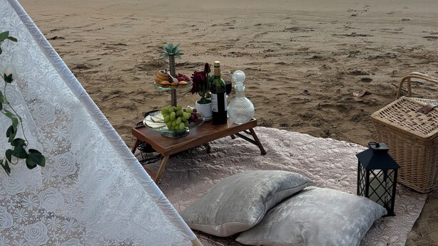 A beach picnic setup with a table, pillows, and a blanket. - Rainforest Escape with Stunning Views minute's drive away from everything! (Río Grande)