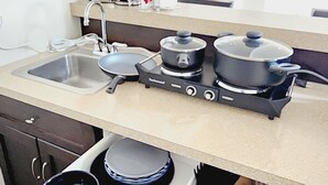 Une cuisine moderne équipée d’un évier, d’une cuisinière et de divers ustensiles.