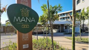 Señal con la leyenda 'MANA Beach Experience', un logo y el número 33.