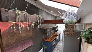 A modern kitchen with a wooden countertop, hanging plants, and a built-in oven. - BurgBnB Downtown (Harrisburg)
