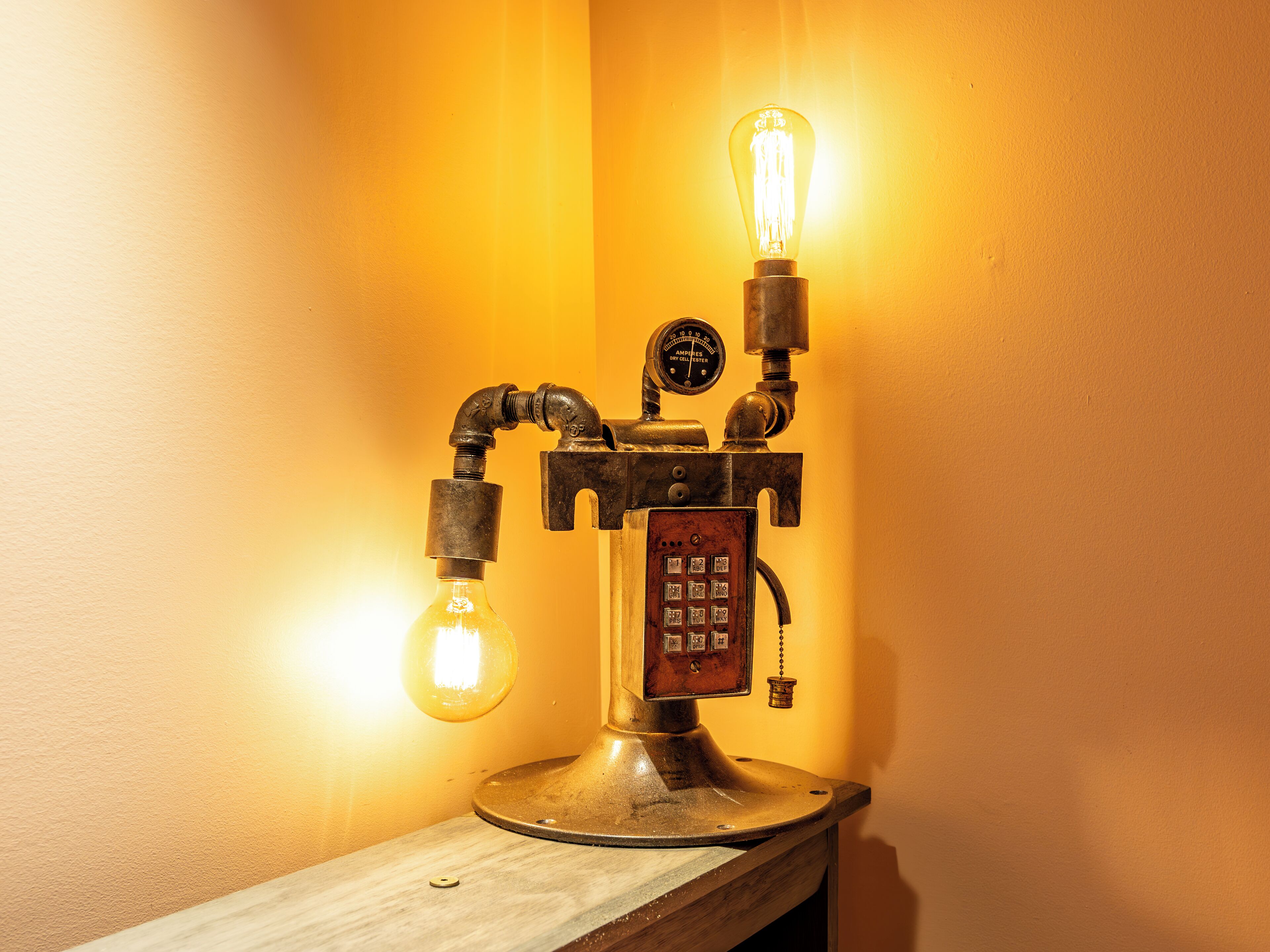 Una lámpara de estilo vintage con bombillas expuestas y un panel de control mecánico.