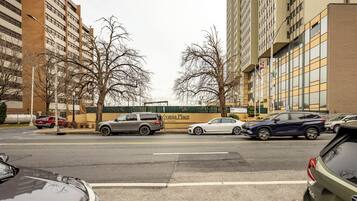 A street view with multiple parked cars, a building with a sign reading 'Chestnut Place,' and a tree-lined sidewalk.