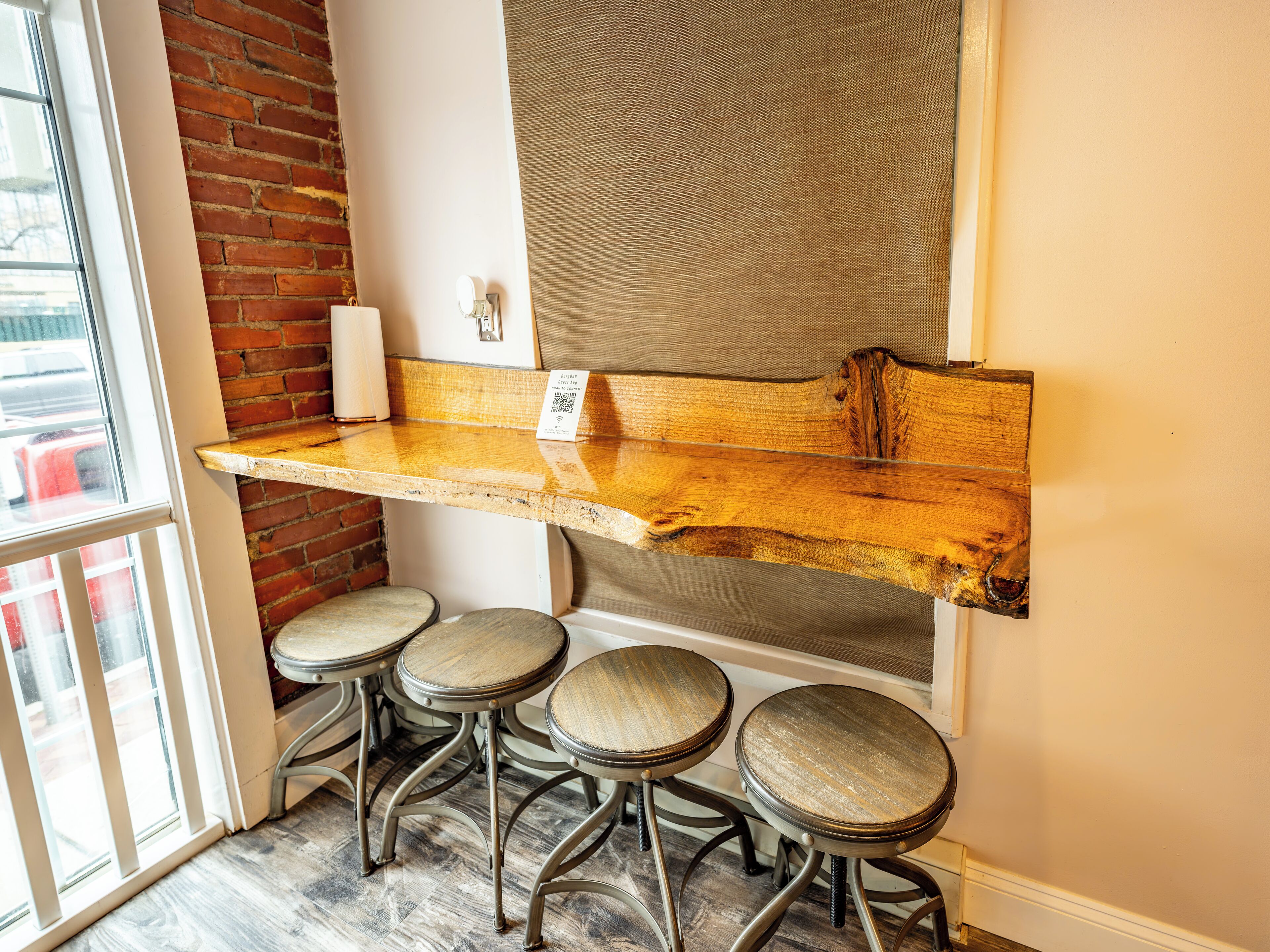 A bar area with a wooden counter and four stools.