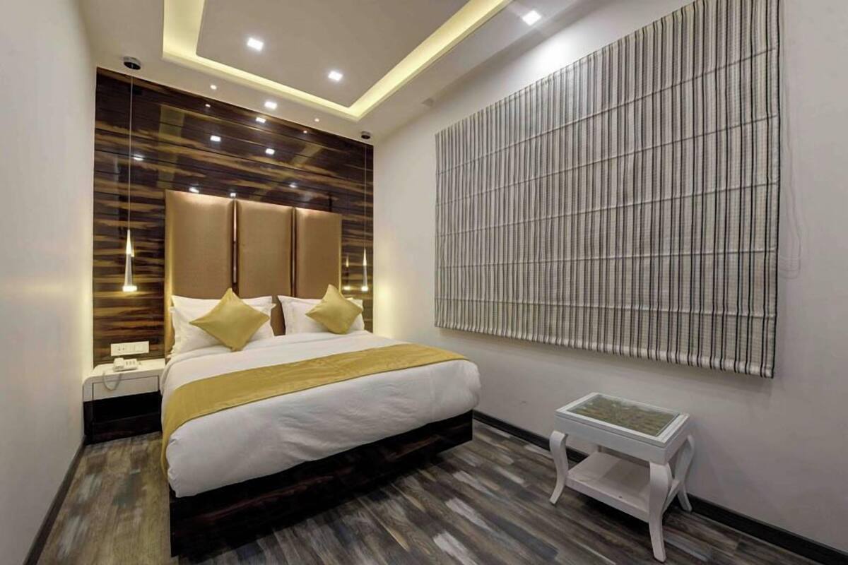 Una habitación de hotel moderna con una cama grande, una mesita de noche y un panel decorativo en la pared.
