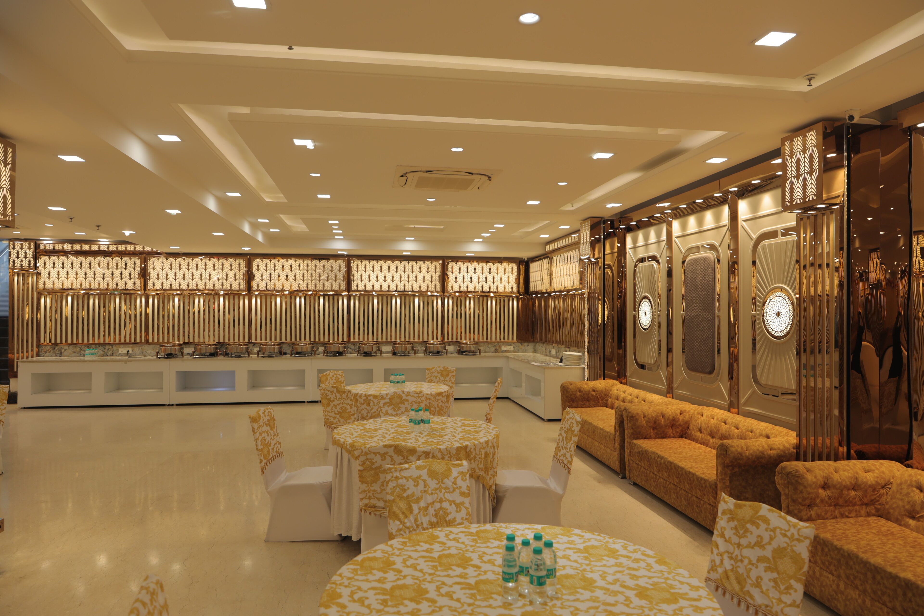 A spacious lobby with multiple seating areas, including round tables and sofas, and a reception desk.