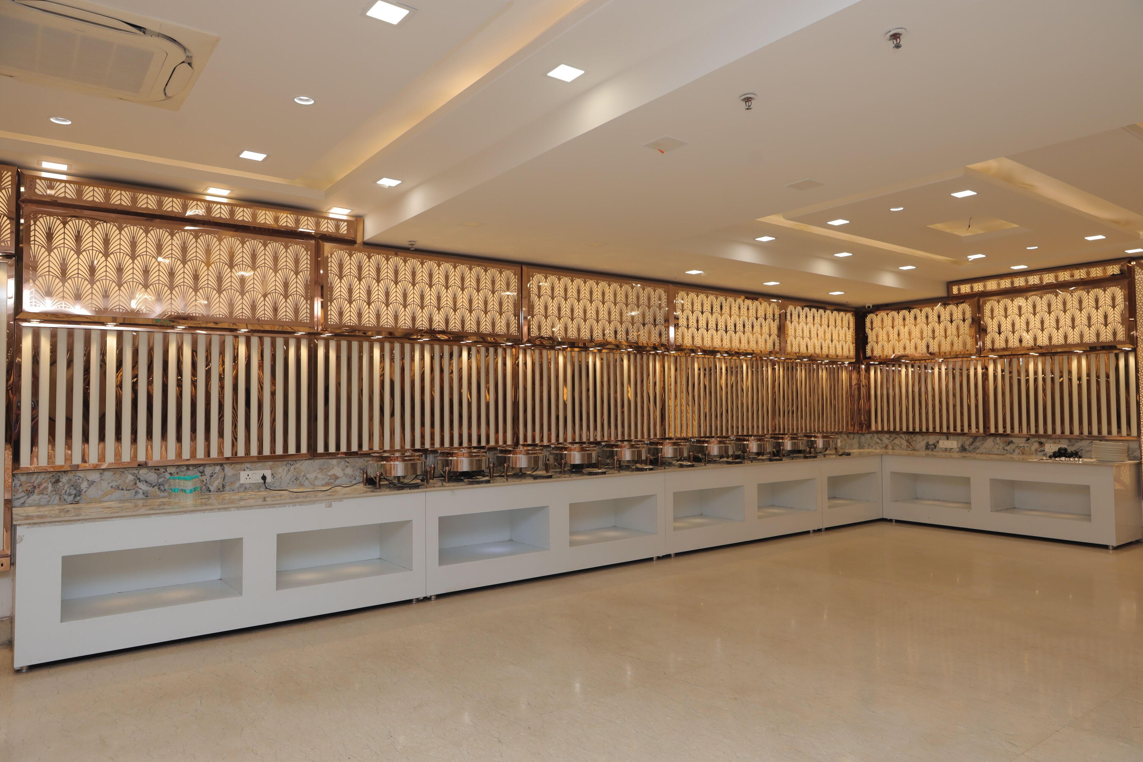 A modern kitchen with a long counter, built-in appliances, and a decorative panel with vertical slats.