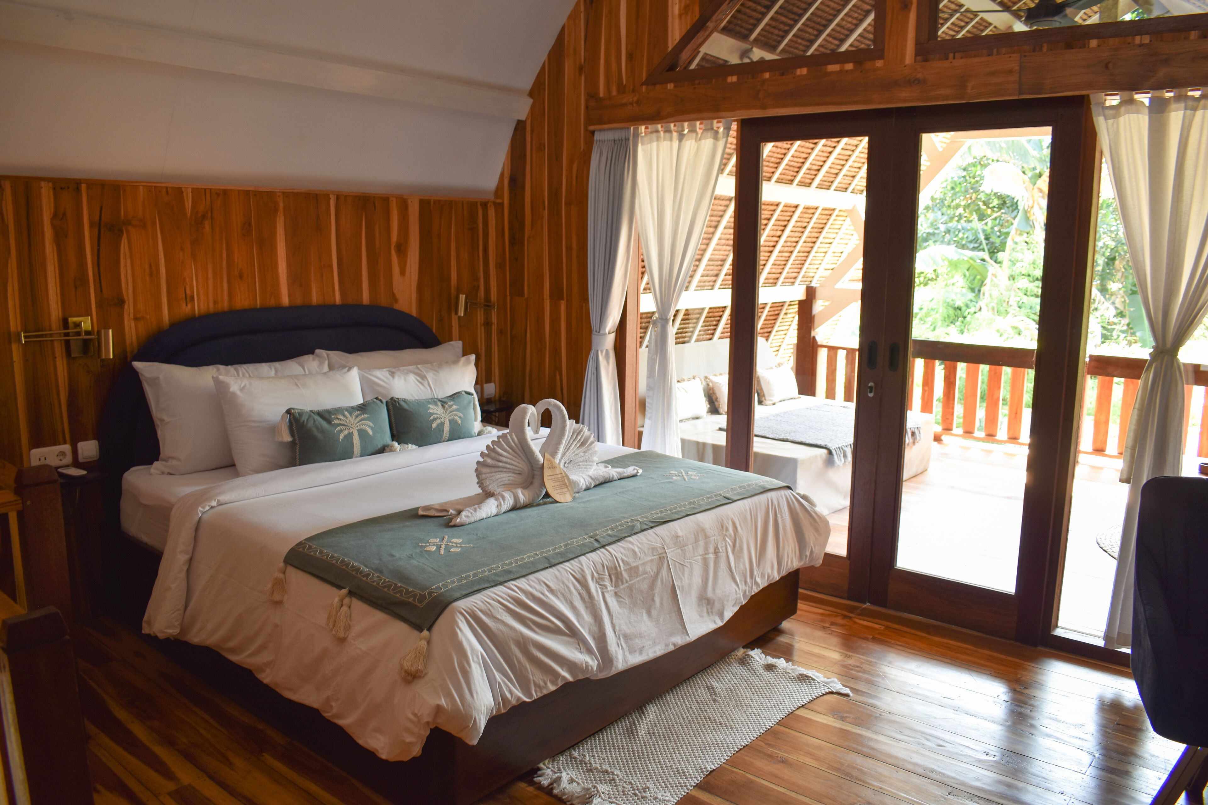 Een slaapkamer met houten frame, een bed, kussens en een decoratie van een zwaan.